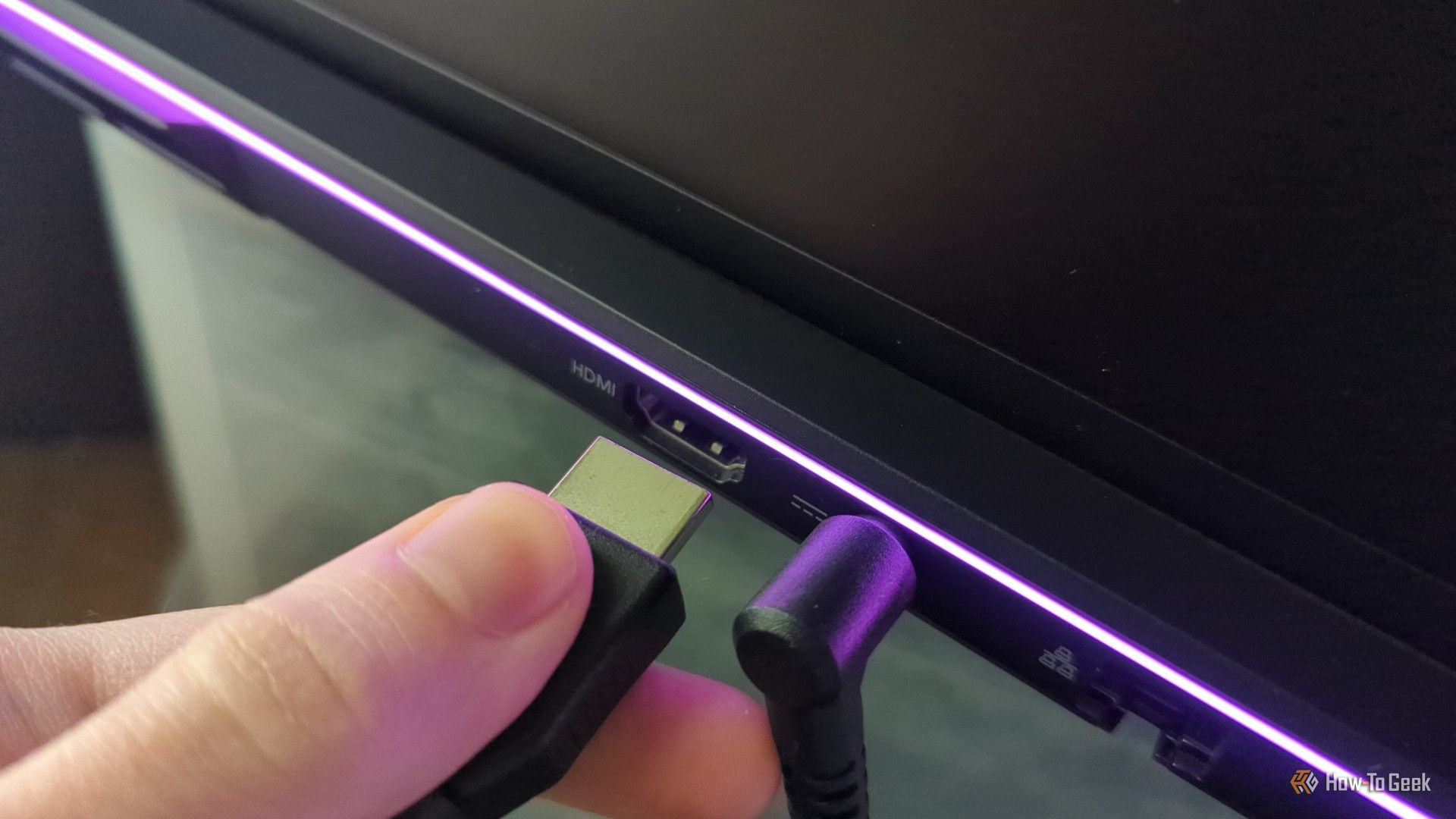 Человек подключает кабель HDMI к ноутбуку