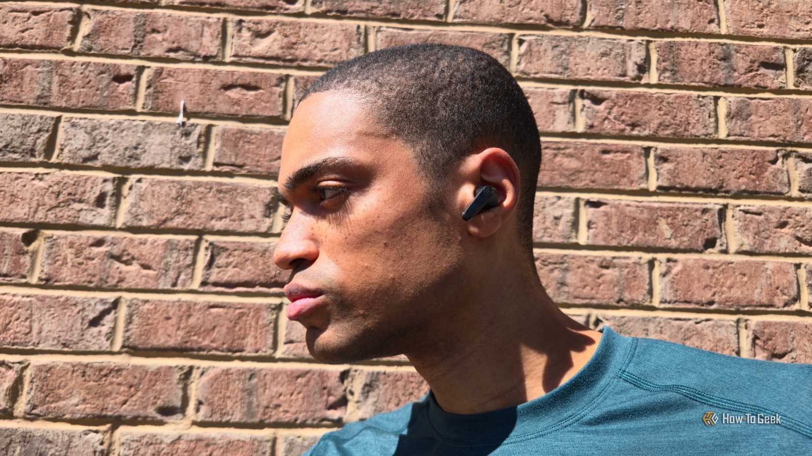 Person wearing JLab JBuds Pods ANC wireless earbuds.
