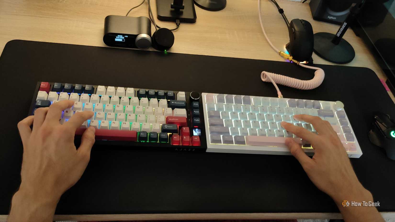 Uma pessoa digitando dois teclados mecânicos simultaneamente.