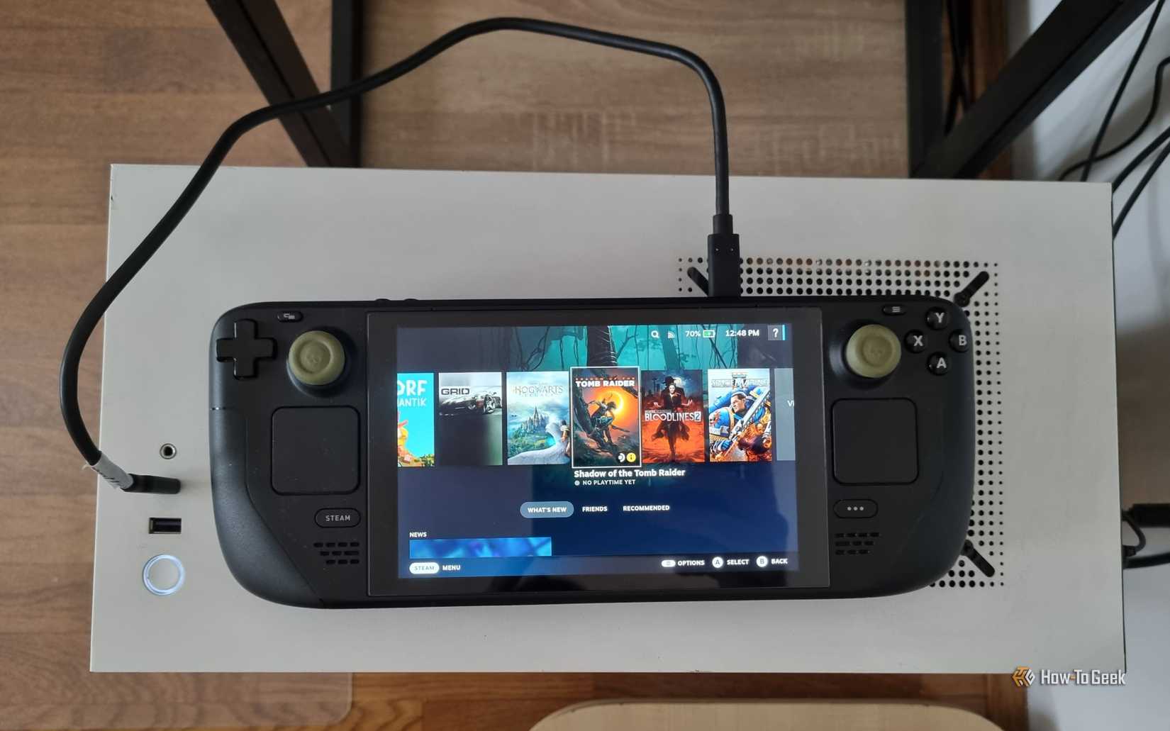 Um Steam Deck conectado a um PC com um cabo USB.