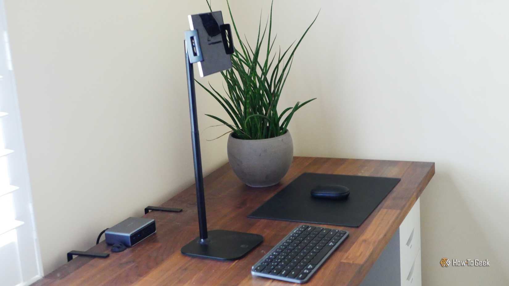 A tall phone stand holding a Galaxy Z Fold 6, next to a keyboard and mouse.