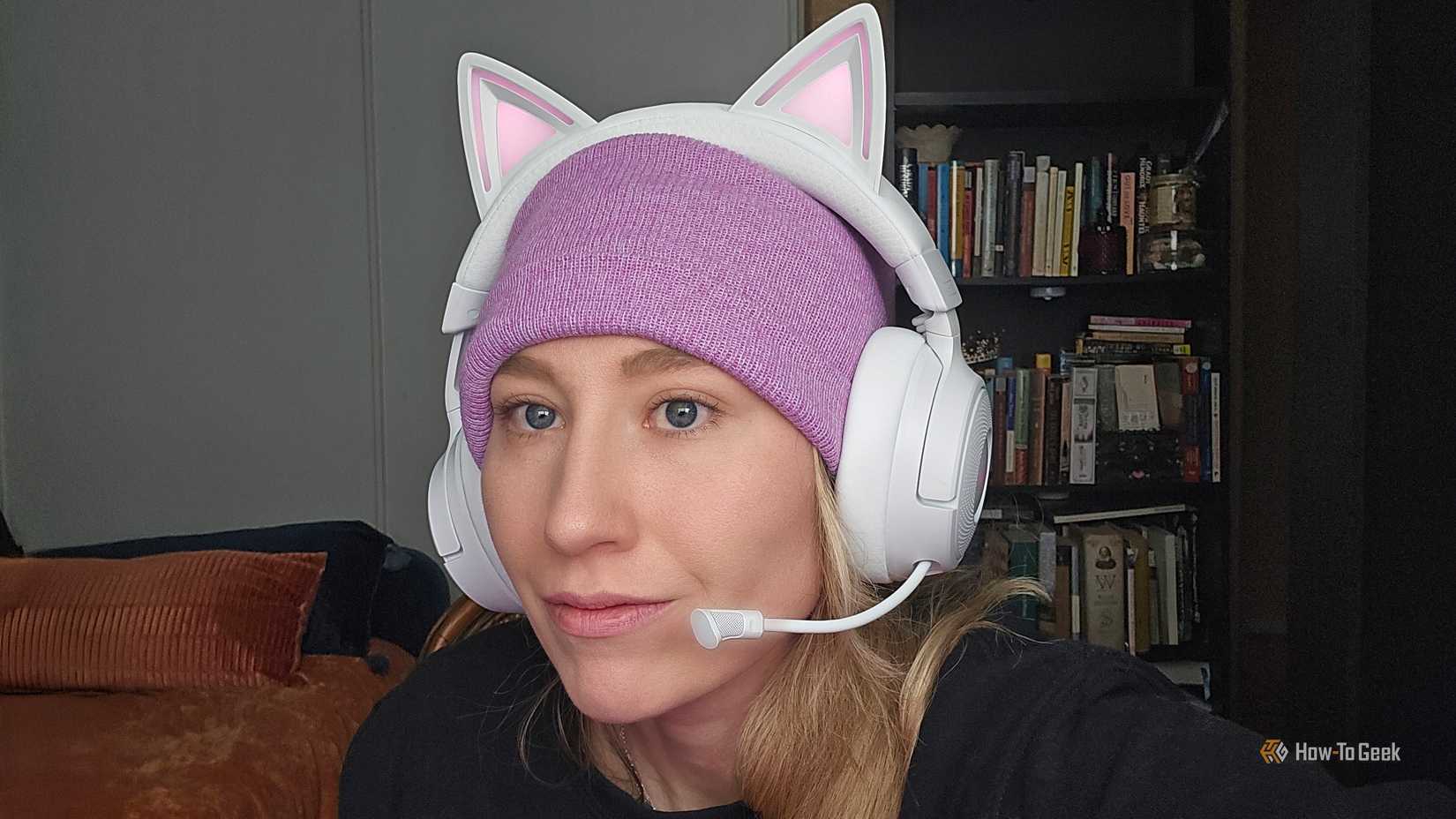 A woman wearing the Razer Kraken Kitty V3 Pro gaming headset with RGB lighting on.