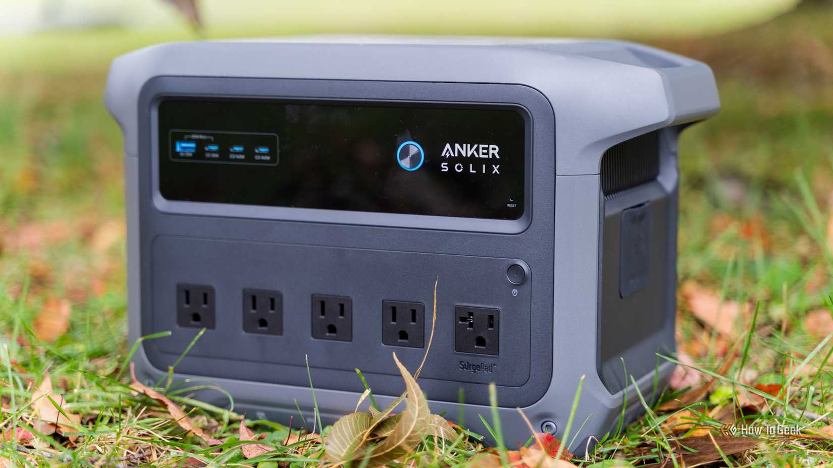 The Anker SOLIX C1000 Gen 2 power station sitting in grass and leaves.