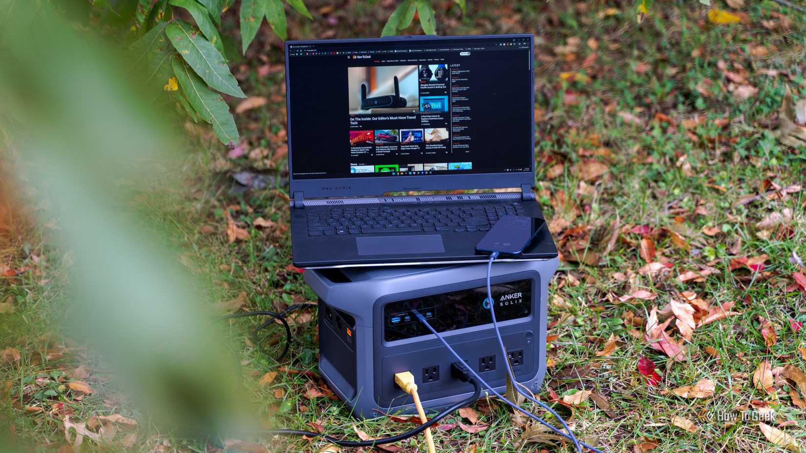 gaming laptop and phone being powered by the Anker SOLIX C1000 Gen 2 portable power station.