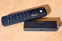 Amazon Alexa Voice Remote Pro sitting next to an Amazon Fire Stick