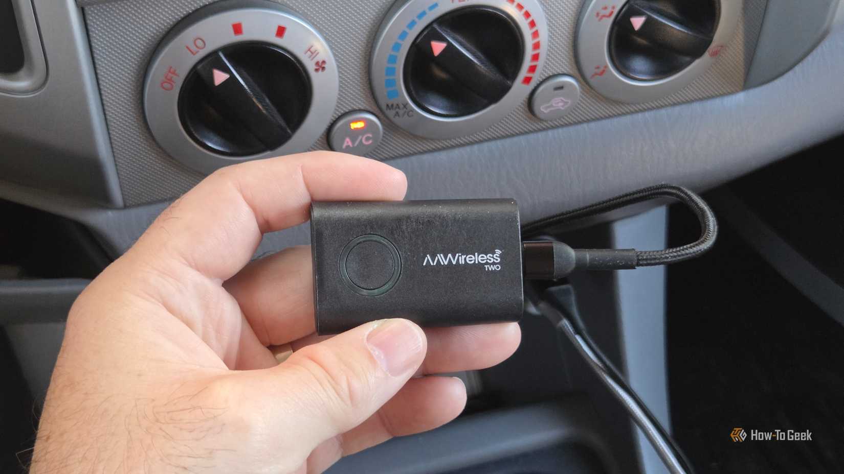 Person holding AAWireless TWO in a car
