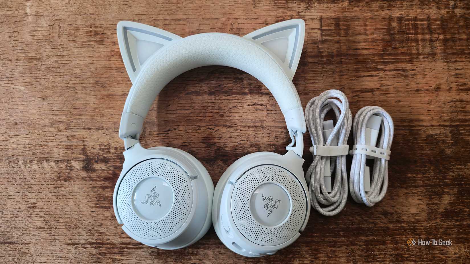 The Razer Kraken Kitty V3 Pro gaming headset and its charging and connection cables.