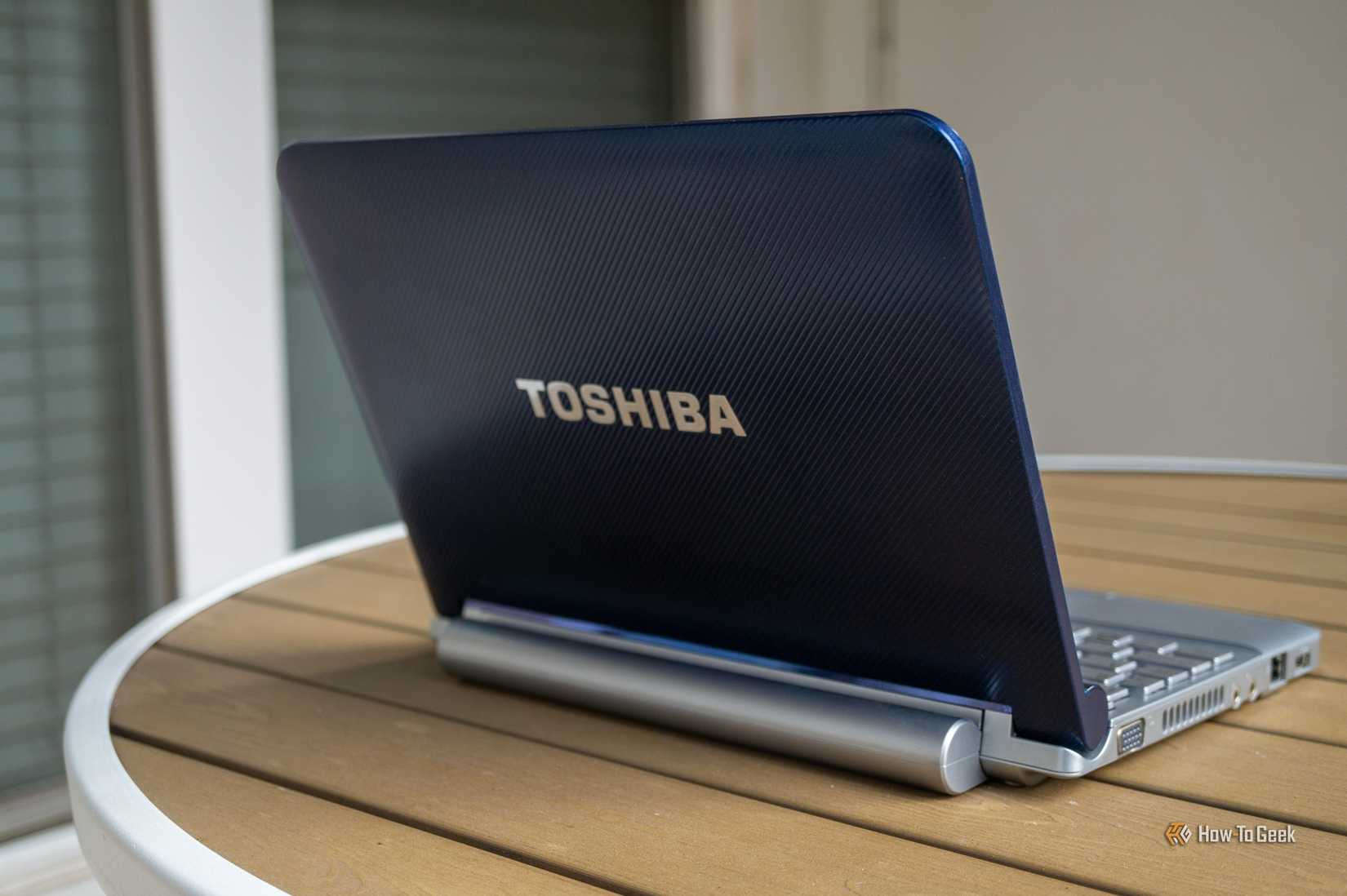 A parte de trás de um netbook Toshiba sobre uma mesa