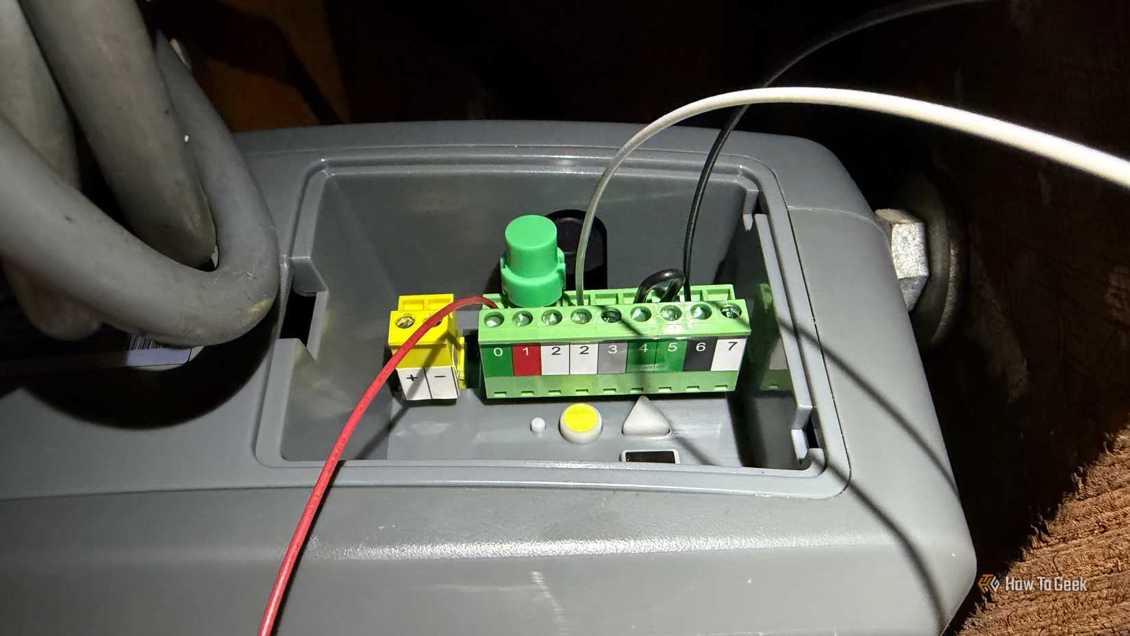 A garage door opener with wires connected to various terminals.