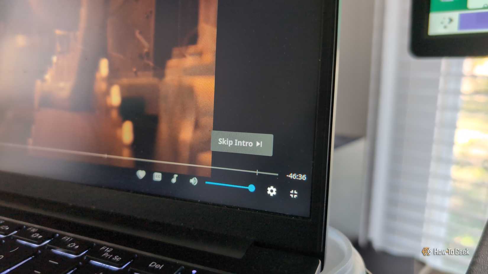 Uma tela de laptop com o player Jellyfin reproduzindo um programa de TV e um botão %22Pular introdução%22 visível no canto.