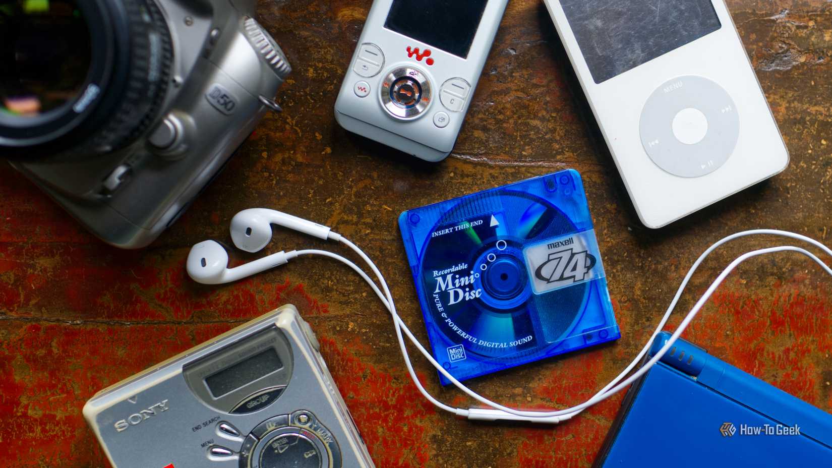 Une sélection de gadgets nostalgiques rétro de la fin des années 2000, notamment un iPod, un lecteur MiniDisc, un reflex numérique et une Nintendo DS.