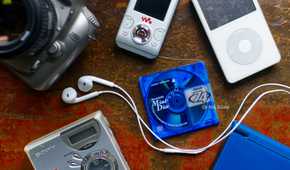 A selection of nostalgic retro late 2000s gadgets including an iPod, MiniDisc player, digital SLR, and Nintendo DS.