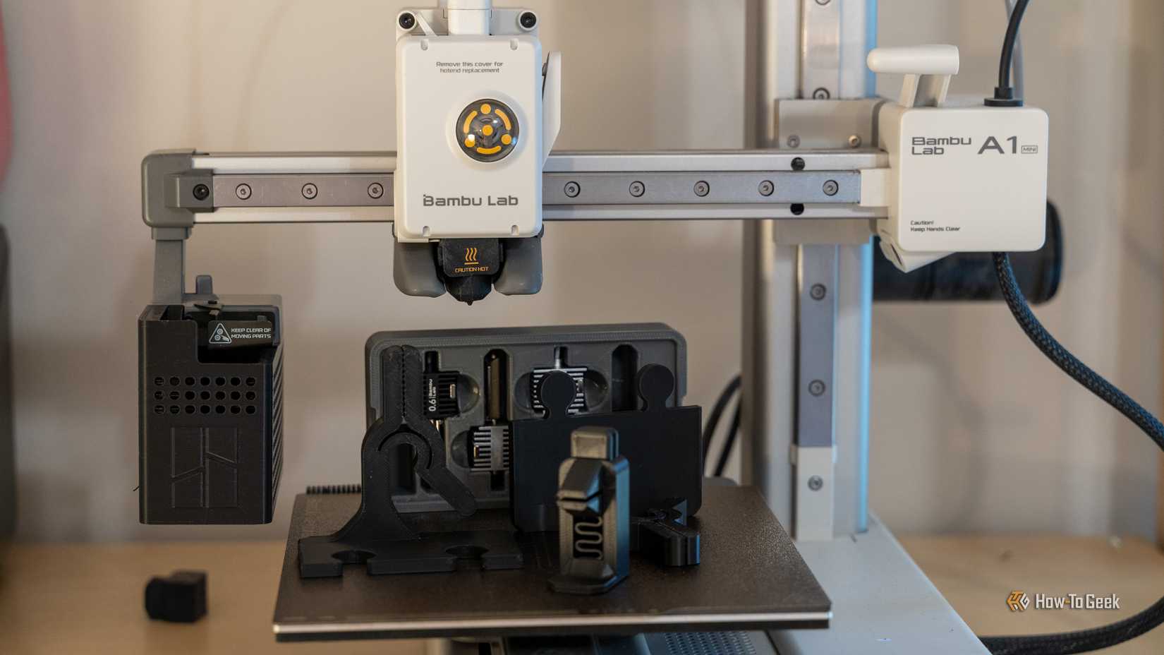 Bambu Labs A1 mini 3D-принтер с напечатанными деталями на платформе.