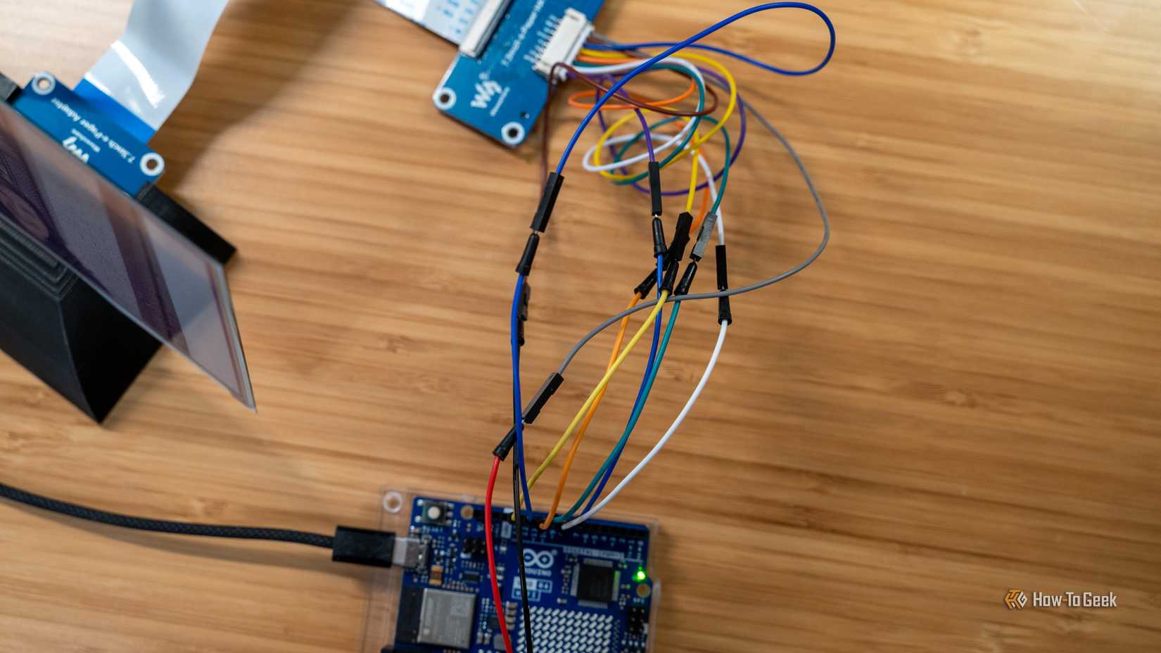 Fios de jumper entre o display de papel eletrônico Waveshare de 7 cores e um Arduino.
