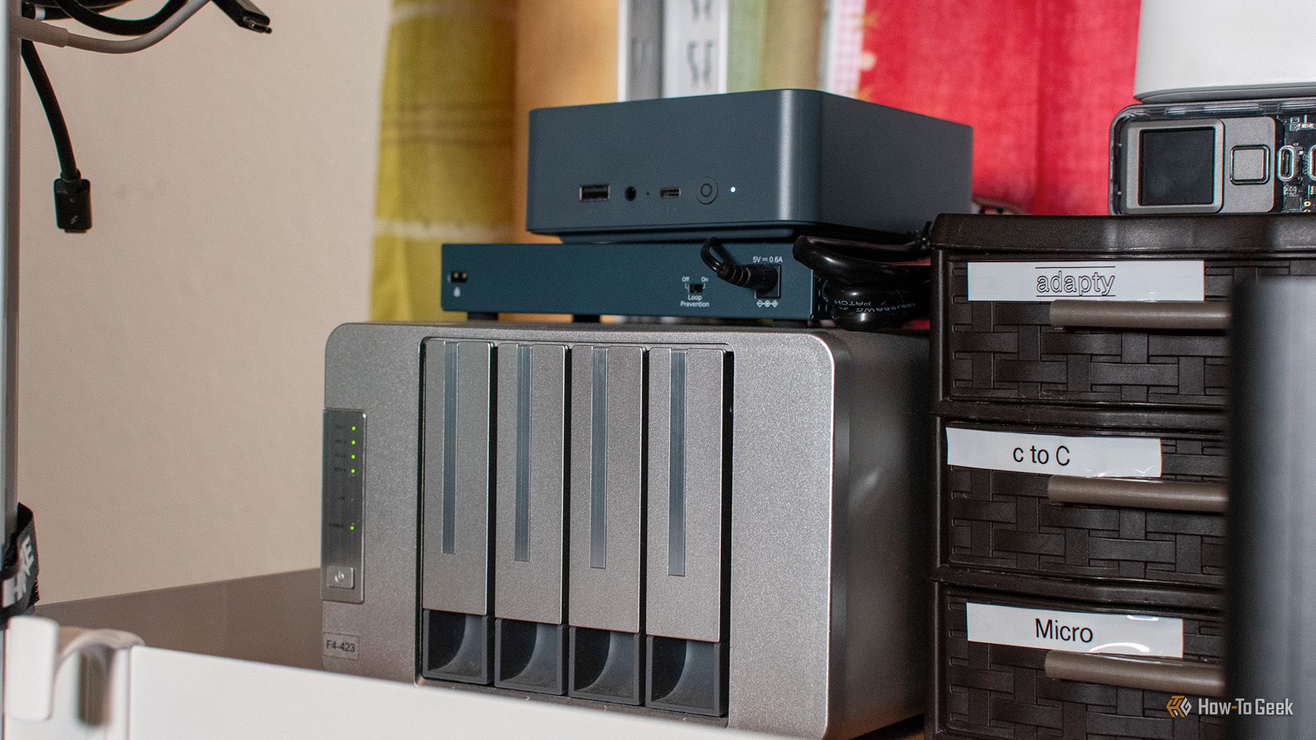 Vista angular de um mini PC Beelink e Terramaster NAS em uma prateleira.