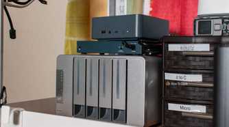 Angled view of a Beelink mini PC and Terramaster NAS on a shelf.
