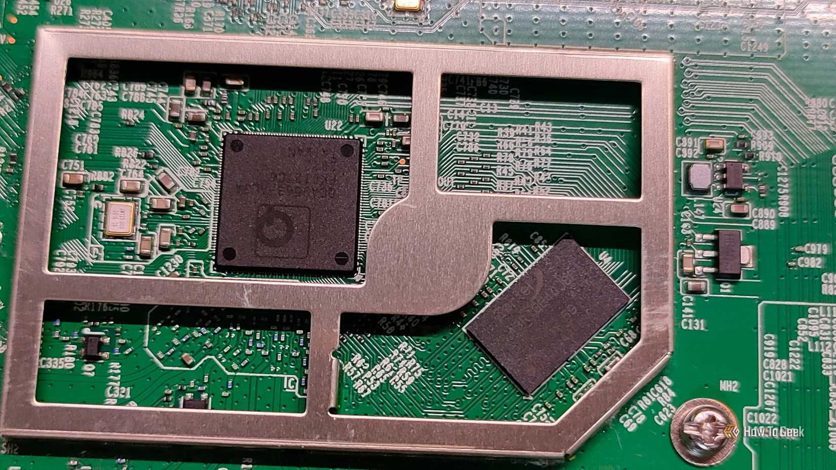 A close-up of a Qualcomm SoC and RAM inside a router.