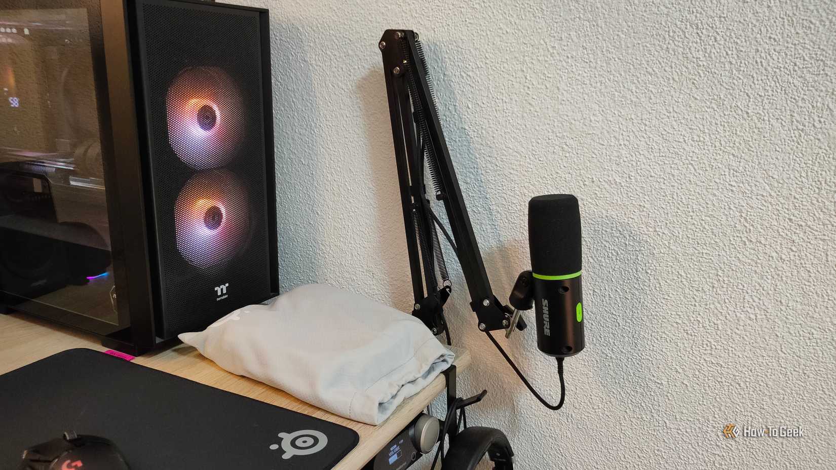 A Shure MV6 mounted on a microphone arm, tucked away into a corner.
