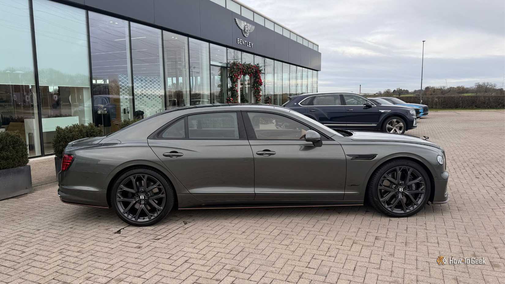 Статический боковой снимок серого Bentley Flying Spur Speed ​​2026 года выпуска.