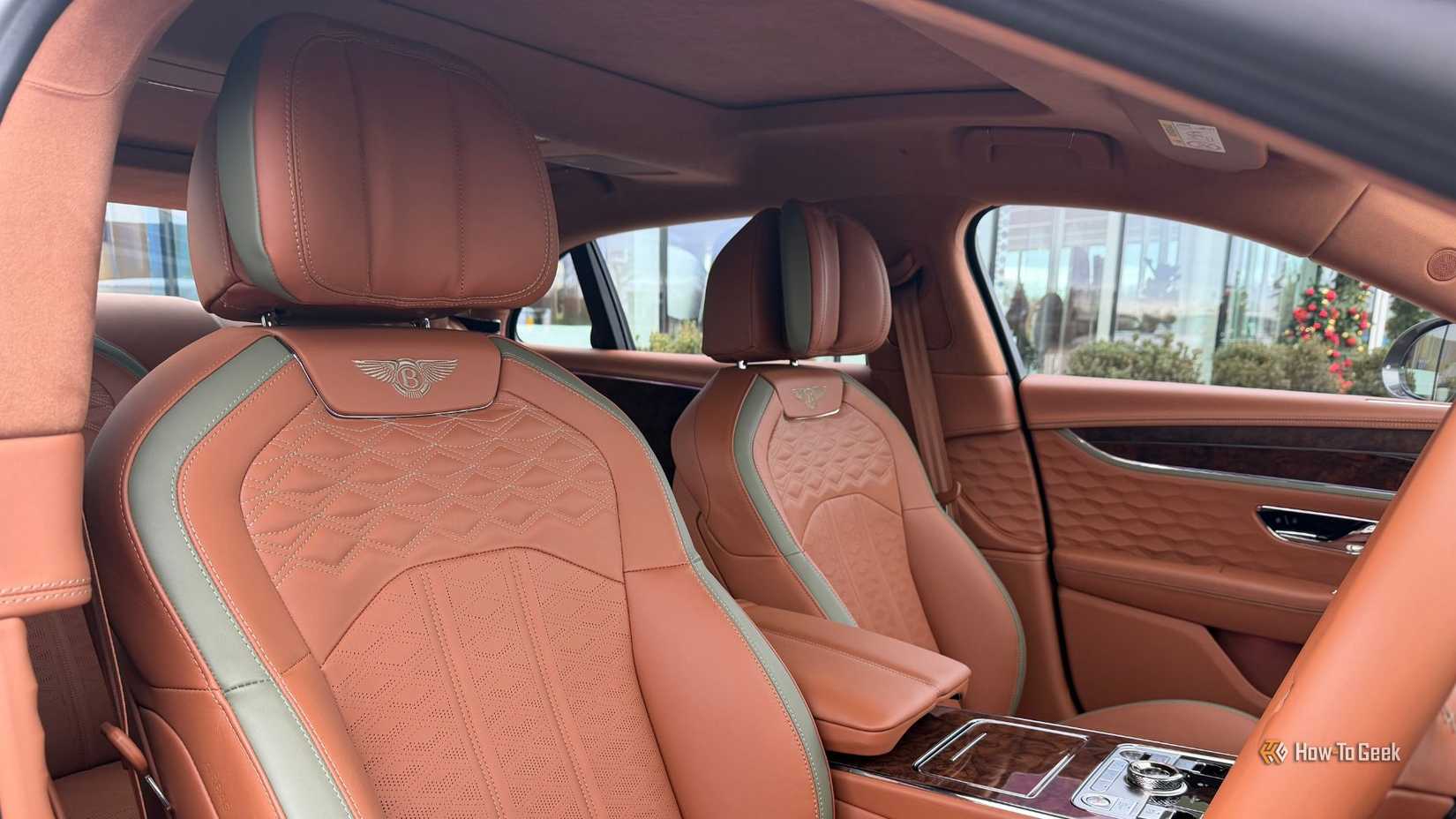 Крупным планом коричневые кожаные передние сиденья Bentley Flying Spur Speed ​​2026 года выпуска.