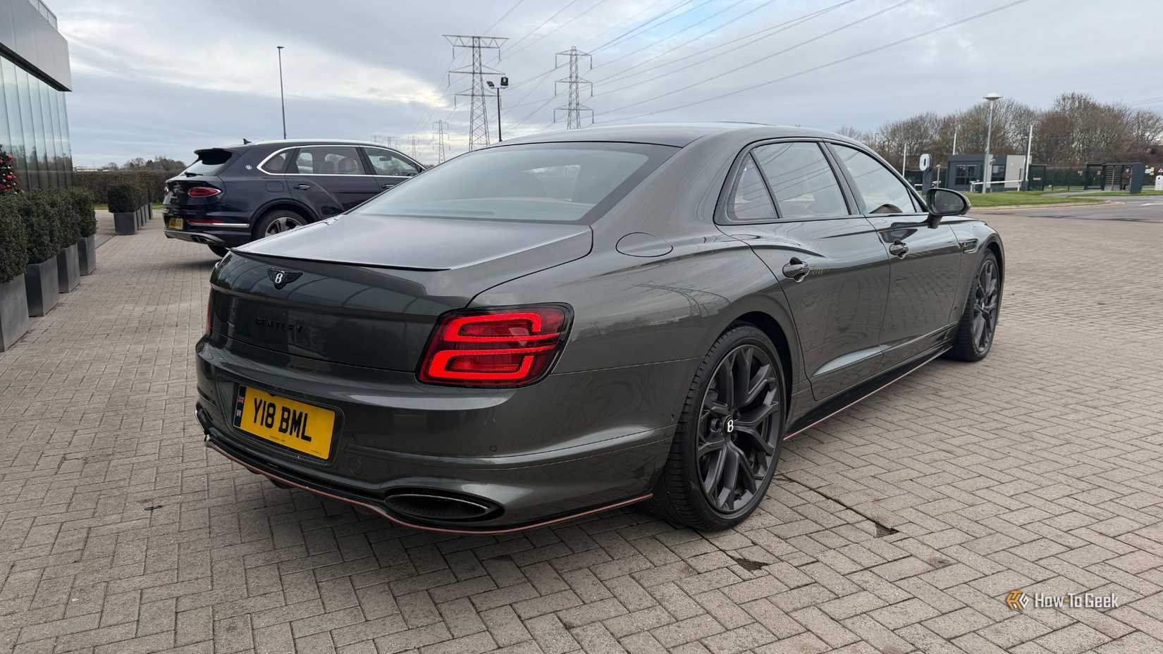 Статичный снимок задней части серого Bentley Flying Spur Speed ​​2026 года выпуска в масштабе 3/4.