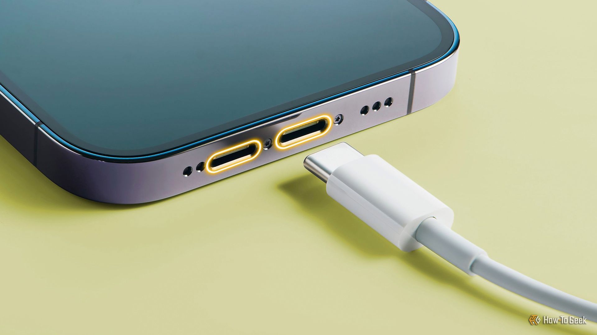 A smartphone with two USB-C ports near a USB-C cable.