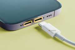 A smartphone with two USB-C ports near a USB-C cable.