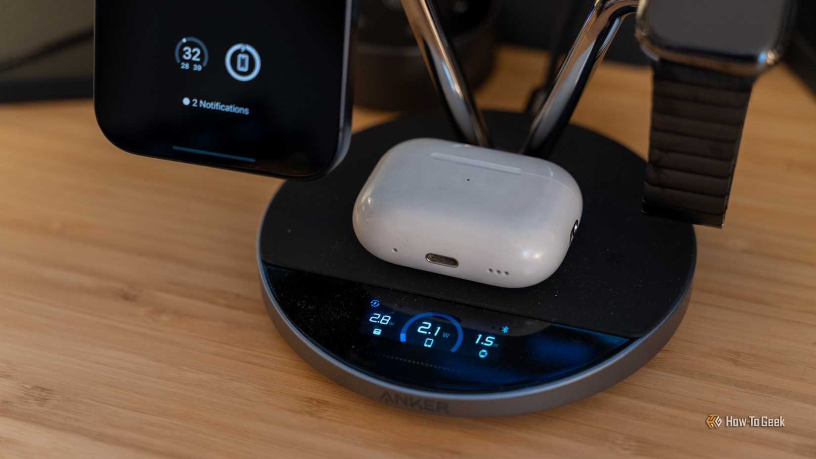 AirPods colocados en la estación de carga inalámbrica Anker Prime con la pantalla que muestra la velocidad de carga de cada dispositivo.