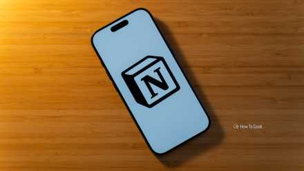 An iPhone 17 Pro with the Notion logo on a white background sitting on a bamboo desk.