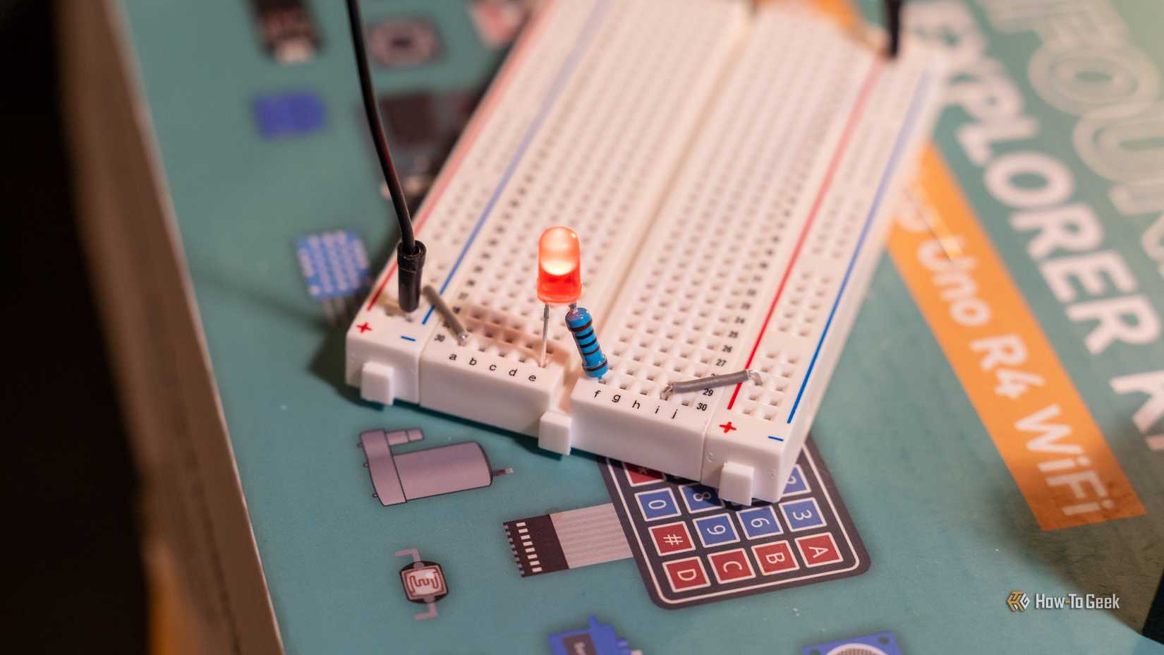 An LED with a resistor soldered to it plugged into a bread board and lit up.