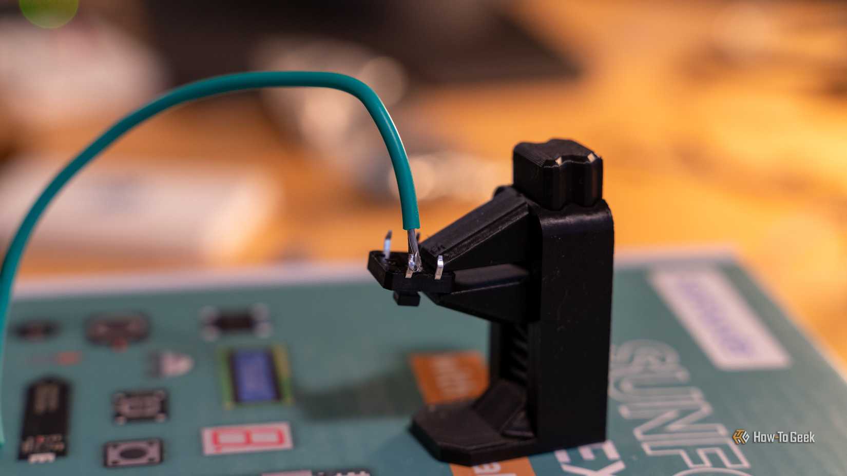 A button with a green wire soldered to it.