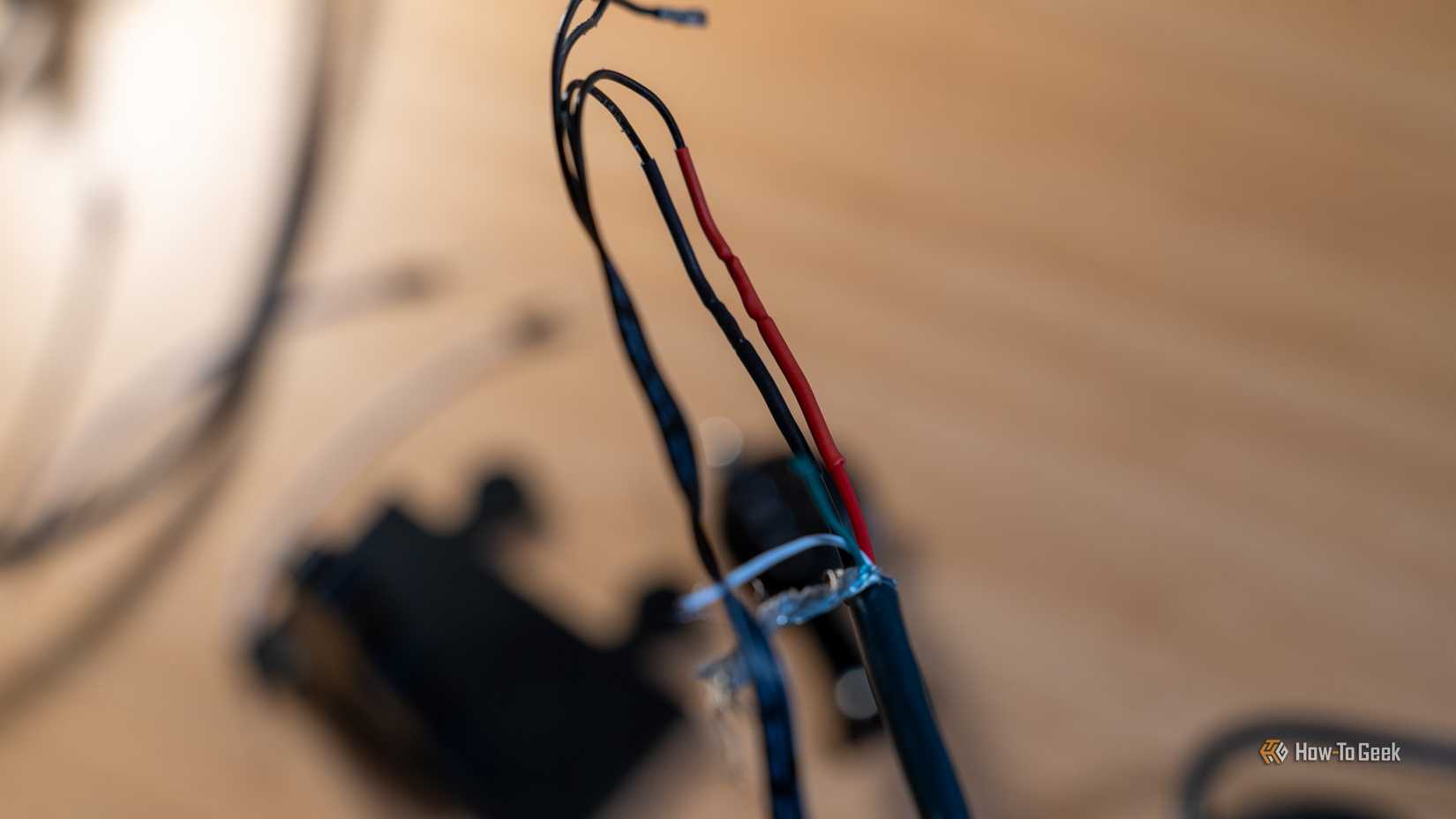 Red and black wires that have been soldered together and secured with heat shrink tubing.