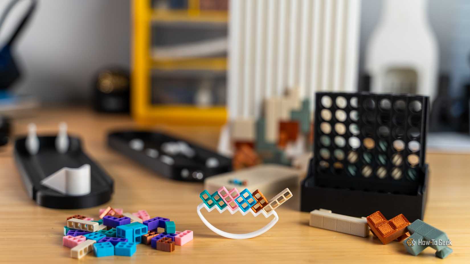 Varios juegos impresos en 3D sobre un escritorio, con Tetris Tumble en el centro.