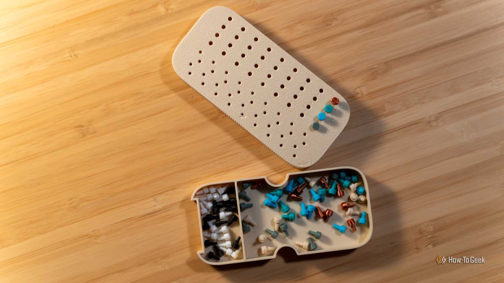 Wydrukowana w 3D gra Mastermind, leżąca na drewnianym biurku.