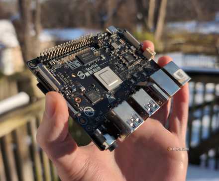 Person's hand holding the VisionFive2 RISC-V single-board computer outdoors.