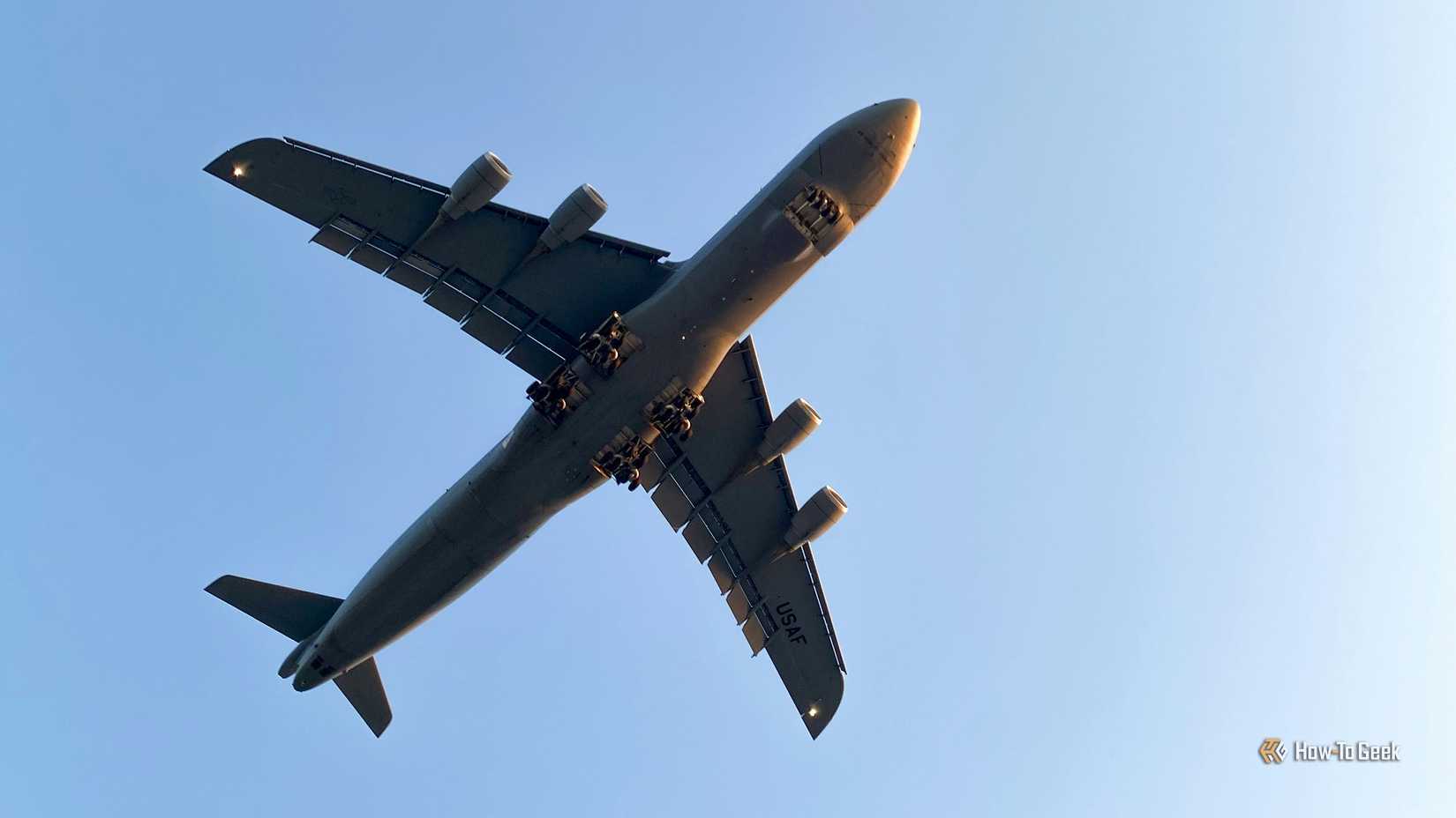 A parte inferior de um avião com um céu azul acima.