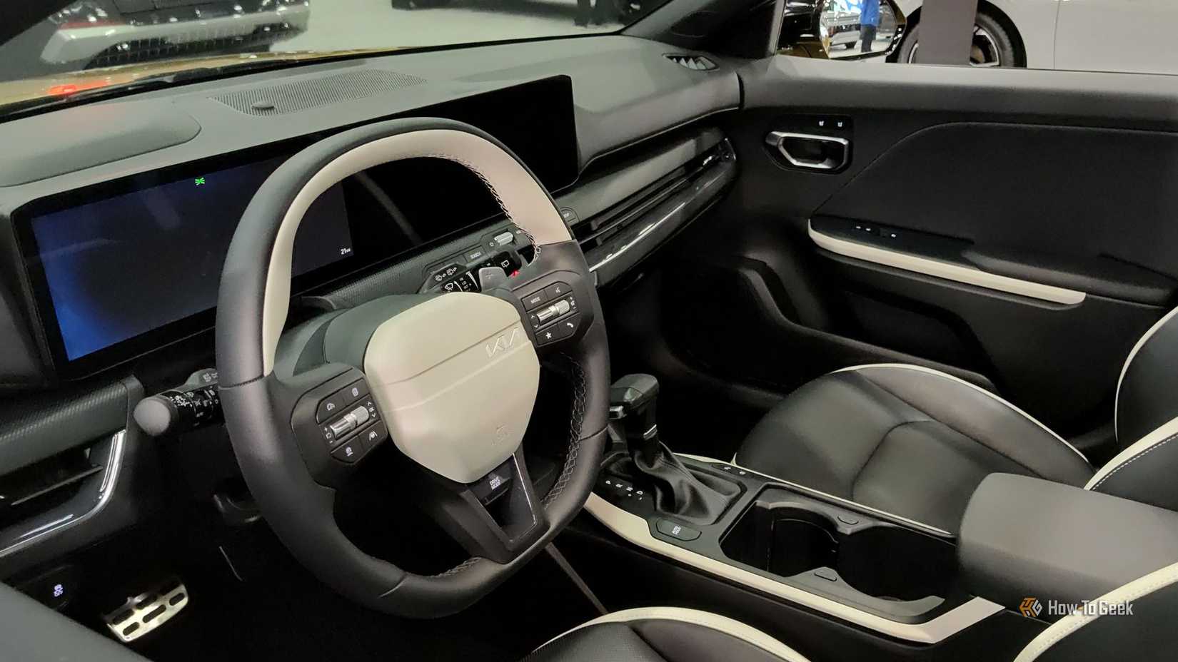 Gros plan du volant et du tableau de bord à l'intérieur de l'habitacle d'une Kia K4 à hayon 2026.