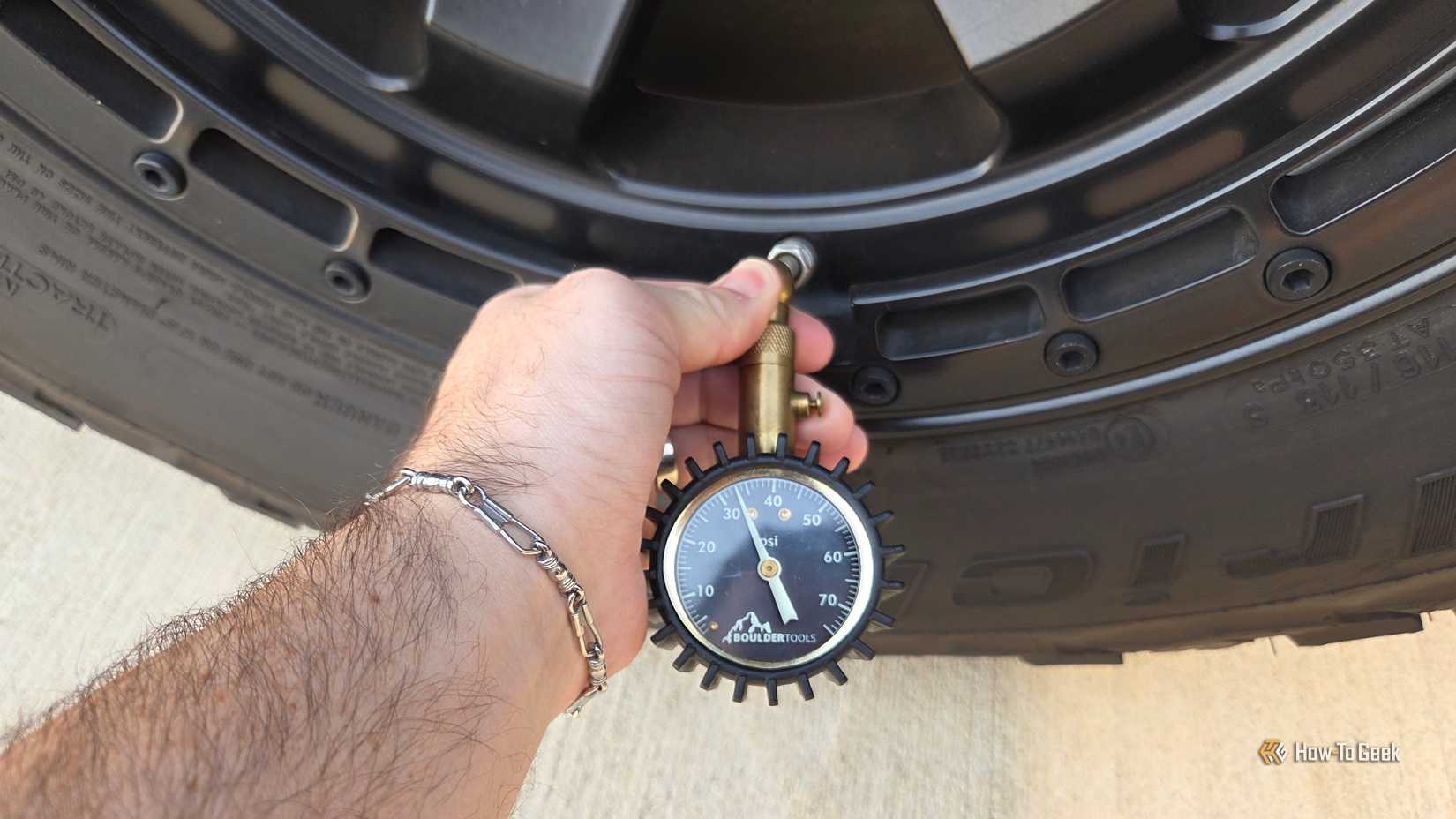 a person checking a car's tire pressure.