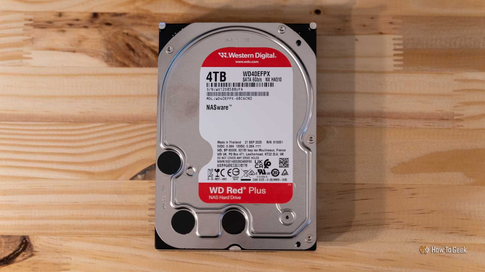 Un disco duro NAS Western Digital WD Red Plus de 4 TB sobre un escritorio de madera.