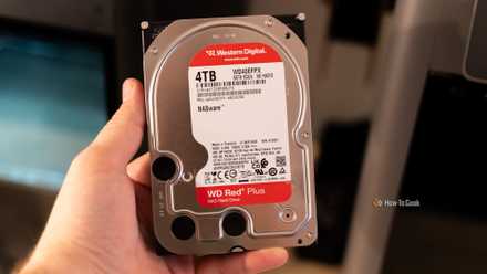 A person holding a Western Digital WD Red Plus 4TB NAS HDD.