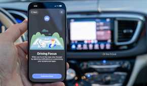 Do Not Disturb While Driving Focus mode shown on an iPhone 17 Pro with Android Auto in the background.