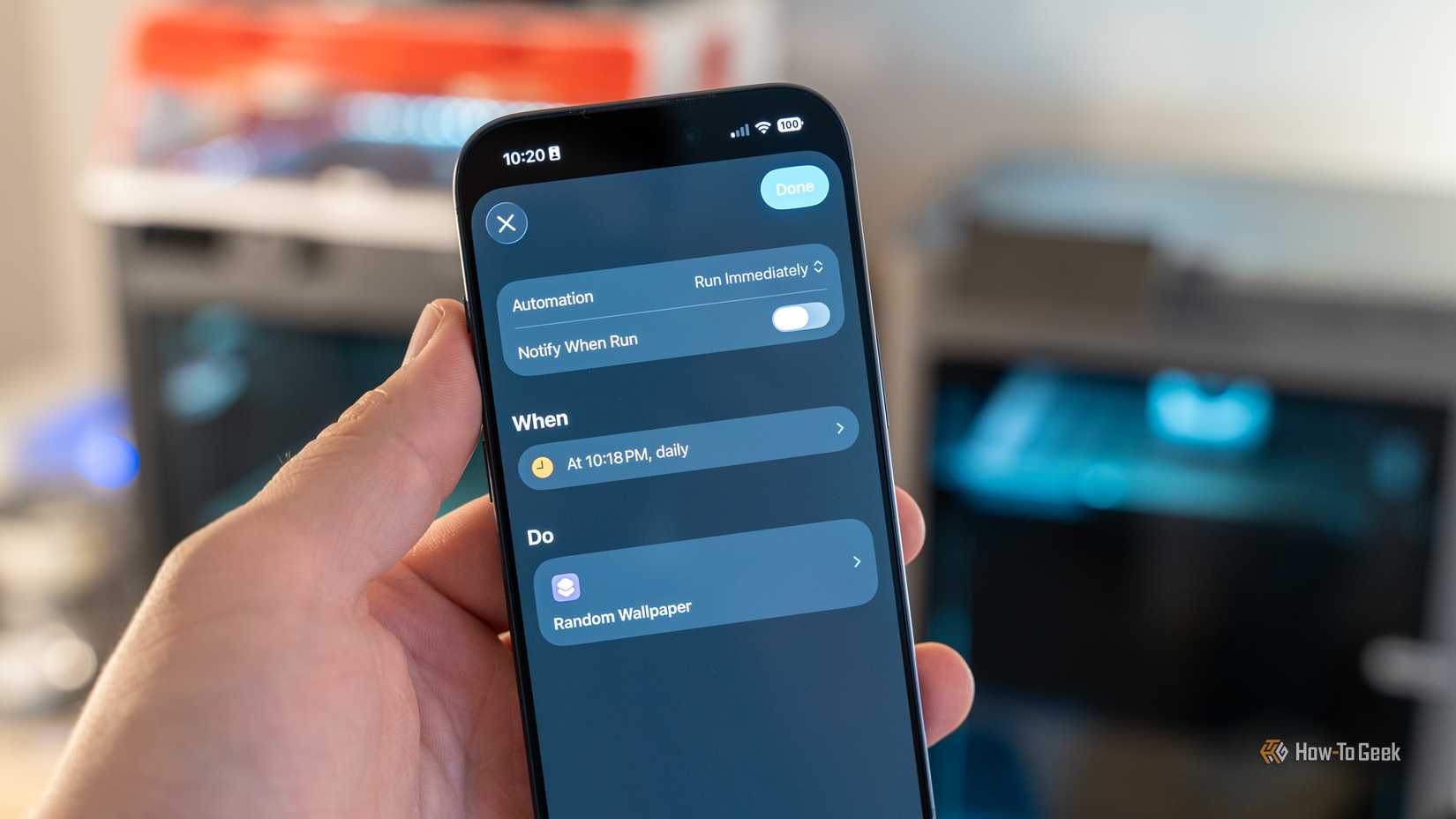 Человек держит iPhone 17 Pro с настроенной автоматизацией для смены обоев в определённое время.
