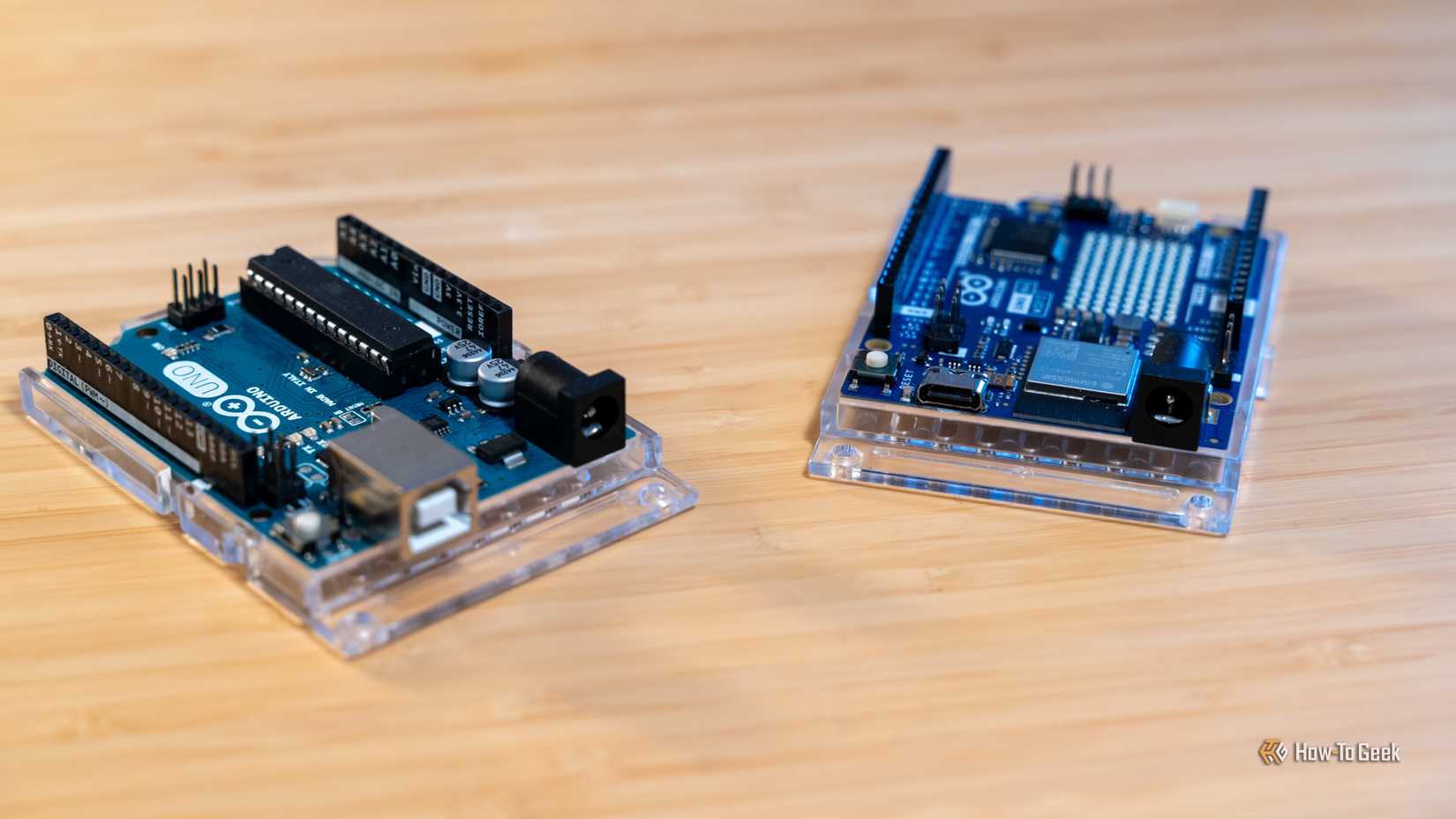 Платы Arduino UNO R3 и UNO R4 Wi-Fi на деревянной поверхности.