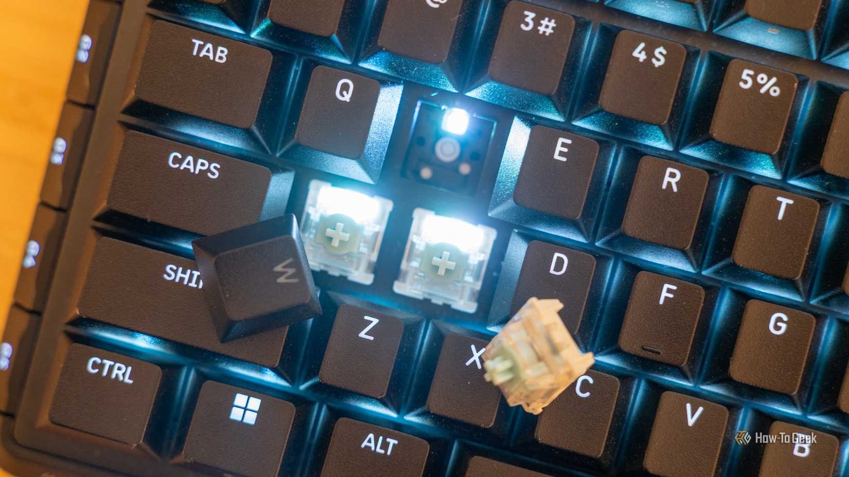 A key switch and key caps removed from the Corsair Vanguard Pro 96 hot-swappable keyboard.
