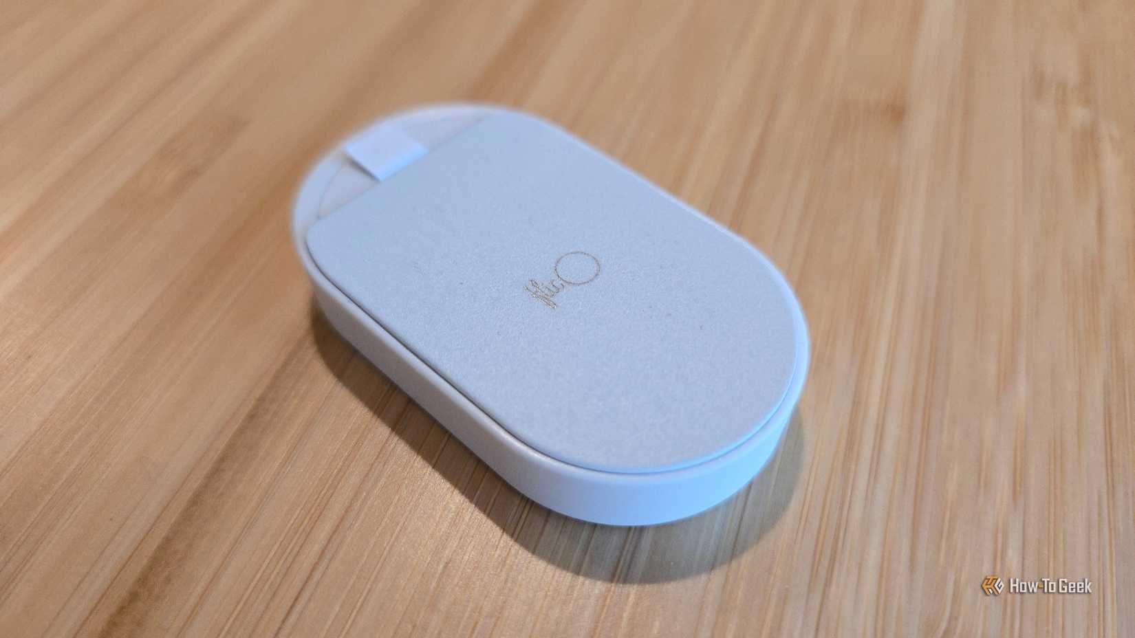 Dos d'un contrôleur de maison intelligente Flic Duo face vers le bas sur une surface en bois.