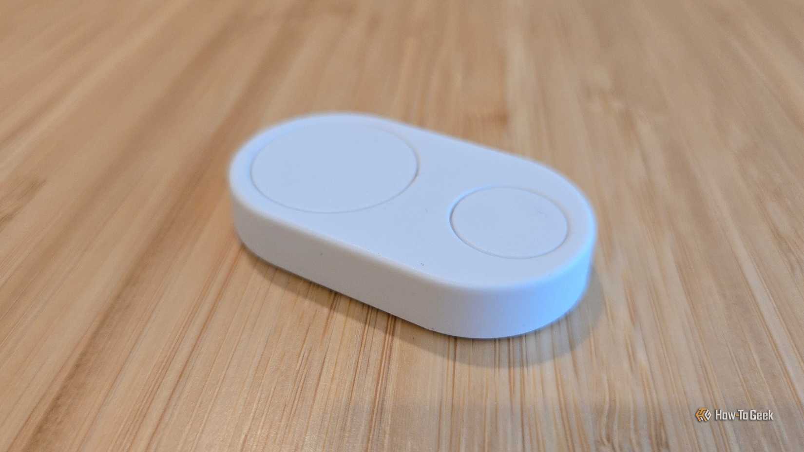 Flic Duo smart home button on a wooden surface.