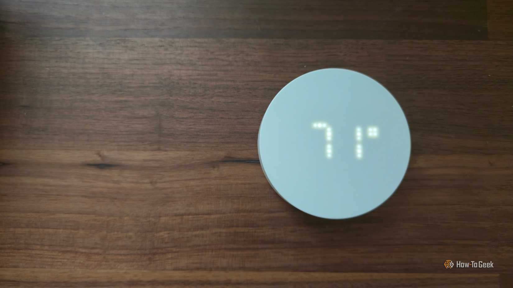 IKEA TIMMERFLOTTE sensor on a desk and displaying the temperature.