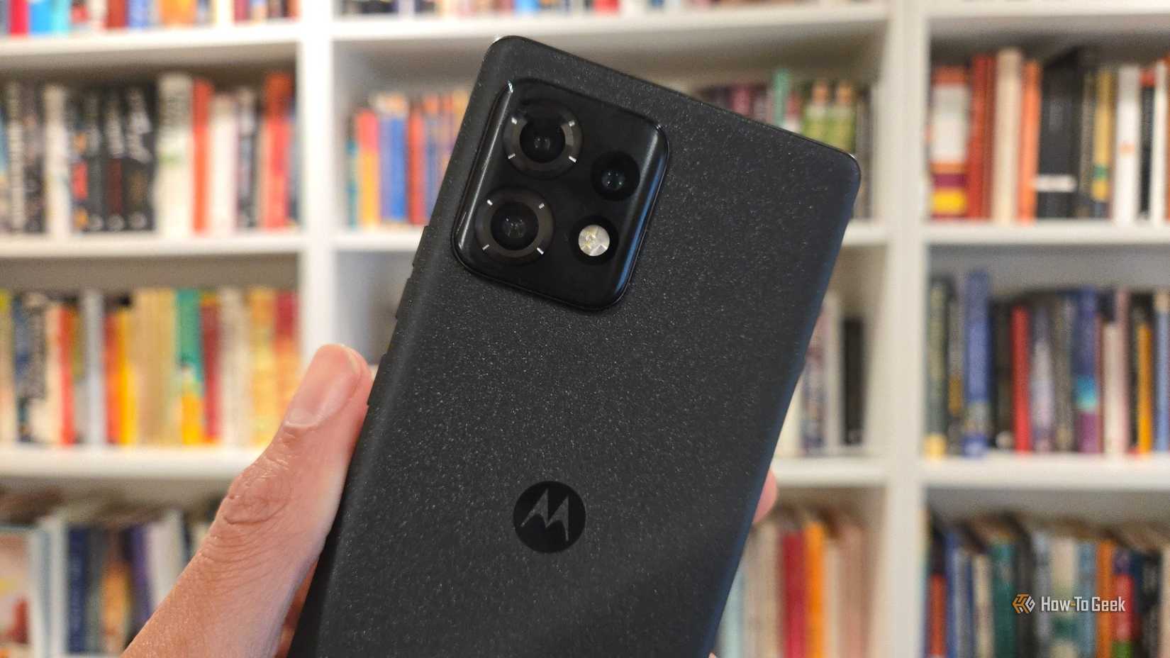 Moto Edge Plus 2023 на фоне книжной полки.