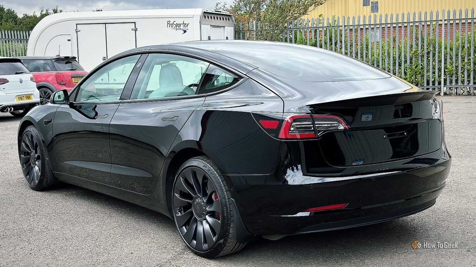 Static rear 3/4 shot of a black 2021 Tesla Model 3 Performance.