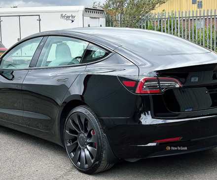 Static rear 3/4 shot of a black 2021 Tesla Model 3 Performance.